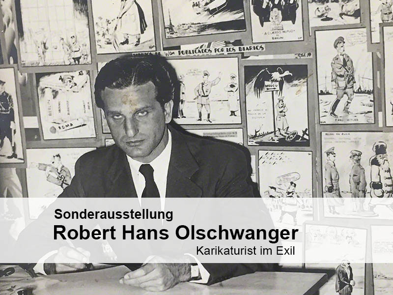 Robert Hans Olschwanger vor seinen Karikaturen