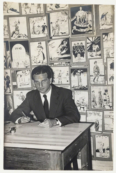 Robert Hans Olschwanger vor seinen Karikaturen